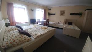 a bedroom with two beds and a table and a window at Mini Apart Hotel Abraka in Český Krumlov