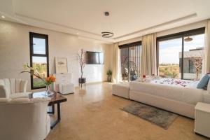 TV a/nebo společenská místnost v ubytování Villa Traverta-marrakech luxe et sérénité, 5 suites, 3 salons européens & 1 salon beldi, cuisine américaine équipée, piscine au sel chauffée, hammam traditionnel & services personnalisés