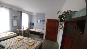 a room with two beds and a room with a table at Mini Apart Hotel Abraka in Český Krumlov