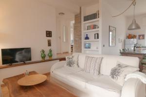 ein Wohnzimmer mit einer weißen Couch und einem Tisch in der Unterkunft Verde Blu Lakefront Boutique Holiday Apartments Trevignano Romano in Trevignano Romano