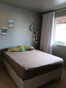 a bed sitting in a bedroom with a window at Verde Mar Abricó 4 in Rio das Ostras