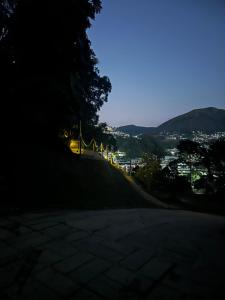 特雷索波利斯Cabana Odara的一条昏暗的街道，街道两旁是一座小山，远处是一座城市。