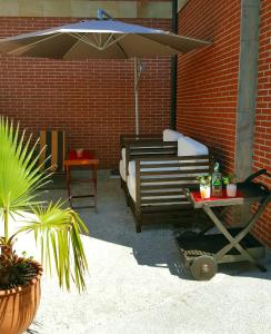 a patio with a bed and an umbrella at Apartamentos Copi Villa de Suances in Suances