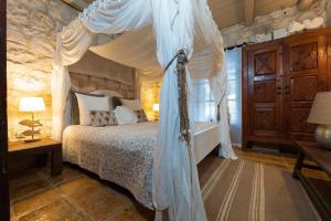 a bedroom with a bed with a canopy at Villa Lalla - Unique Location, Private Pool & Spacious Garden, Ideal for Large Groups in Lithakia