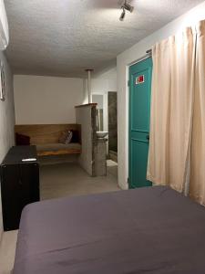 a room with a bed and a blue door at Nómadas Hostel in La Paz