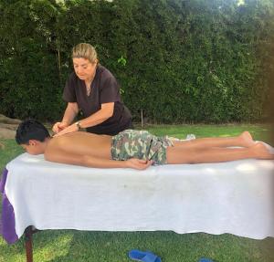 a woman giving a boy a massage on a table at Un oasis de tranquilidad y diversión familiar in Yautepec