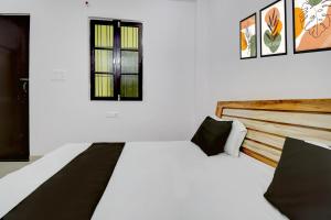 a white bedroom with a bed and a window at HOTEL O AS PALACe in Lucknow