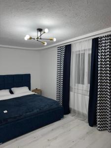 a bedroom with a blue bed and curtains at Fochyn House in Krivorovnya