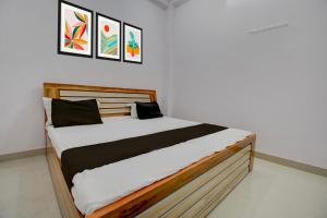 a bed in a room with paintings on the wall at HOTEL O AS PALACe in Lucknow +21 photos