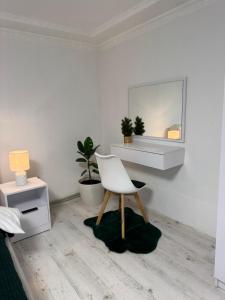 a white room with a chair and a mirror at Fochyn House in Krivorovnya