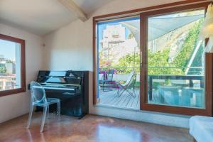 ein Wohnzimmer mit einem Klavier und einem Balkon in der Unterkunft vue de rêve au vallon des auffes, 13007 marseille in Marseille