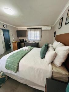 a bedroom with a large white bed with pillows at Hope Villa Luxury Accomodation in Odendaalsrus +27 photos