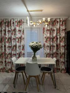 a dining room with a table with chairs and a vase of flowers at Fochyn House in Krivorovnya +27 photos