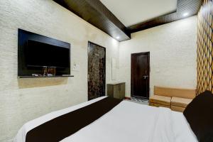 a bedroom with a bed and a flat screen tv at HOTEL O THE 9 CUBE in Habībganj
