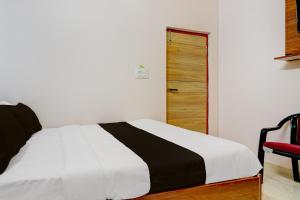 Un dormitorio con una cama y una silla roja. en Hotel O R R Comforts Boarding and Lodging, en Nelamangala 20 fotos más