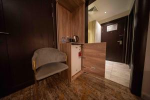 a small kitchen with a chair and a refrigerator at Afaq Taiba Hotel in Medina