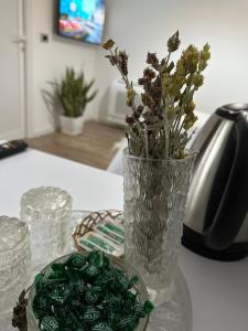a glass vase with flowers in it on a table at Mosaic Guesthouse in Lin +38 photos