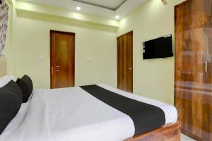 a bedroom with a bed and a flat screen tv at Hotel O Jerry Guest House & Caf� By CheckIn in Bishnupur
