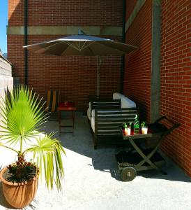 a patio with a bed and an umbrella and a table at Apartamentos Copi Villa de Suances in Suances