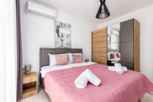 ein Schlafzimmer mit einem rosa Bett mit Handtüchern darauf in der Unterkunft Mira Bay in Igalo + 15 Fotos