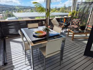 a table and chairs on a deck with a view at Unique city bungalow in Whangarei