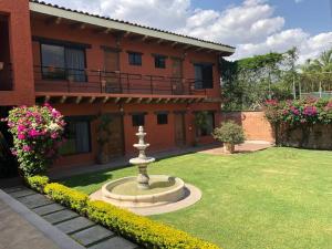 a garden in front of a house with a fountain at Un oasis de tranquilidad y diversión familiar in Yautepec