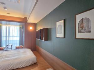 a bedroom with a white bed and a green wall at 스테이 마루 종로 Stay Maru Jongno in Seoul