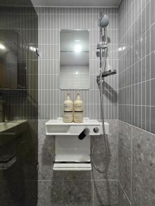 a bathroom with a shower with two bottles on a sink at 스테이 마루 종로 Stay Maru Jongno in Seoul