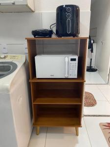 een magnetron op een plank naast een wasmachine bij Park Barra Mais Viver in Barra dos Coqueiros