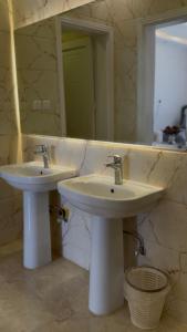 a bathroom with two sinks and a mirror at Apartment in Tabuk +12 photos