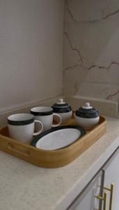 a tray with four bowls and cups on a counter at Apartment in Tabuk