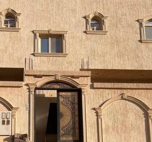 a building with a door and two windows on it at Apartment in Tabuk