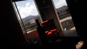 a chair and a wine glass in front of a window at DEPARTAMENTOS BOUTIQUE DE DISEÑADOR " TERRAZA 26" - Cochera- Vista a la Montaña- CANCELACIÓN GRATUITA- PAGARÁS EN EL ALOJAMIENTO in Mendoza