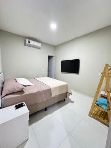 a bedroom with a bed and a flat screen tv at Casa Paradise in Jijoca de Jericoacoara +37 photos