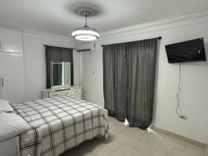 a bedroom with a bed and a television in it at Modern Getaway with Private Pool, Montecristi in Villa Vásquez