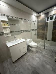 a bathroom with a toilet and a sink and a shower at Modern Getaway with Private Pool, Montecristi in Villa Vásquez +11 photos