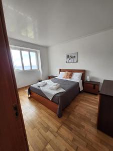 een slaapkamer met een bed en een houten vloer bij Casa dos Amigos in Angra do Heroísmo