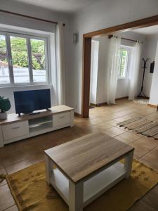 een woonkamer met een tv en een salontafel bij Casa dos Amigos in Angra do Heroísmo