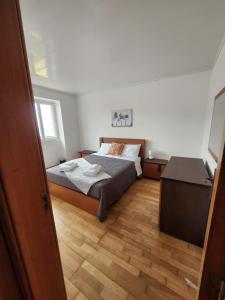 een slaapkamer met een bed en een houten vloer bij Casa dos Amigos in Angra do Heroísmo