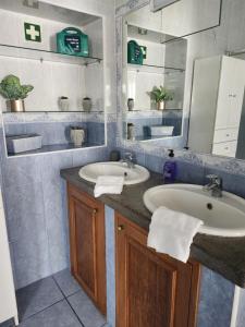een badkamer met een wastafel en een spiegel bij Casa dos Amigos in Angra do Heroísmo