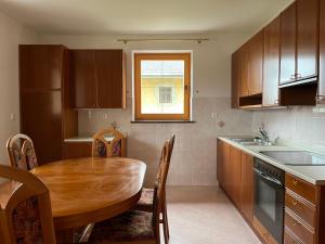 a kitchen with a wooden table and a table and chairs at Pr Fajfarju in Spodnja Sorica