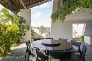 a patio with a wooden table and chairs at Cohost Casa Pedra do Anel in Vila Velha