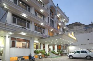 un coche blanco estacionado frente a un edificio en Le Grand Hotel, en Haridwar