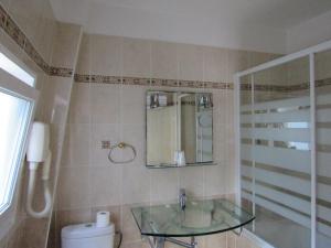 a bathroom with a glass sink and a toilet at Hôtel du Square d'Anvers in Paris