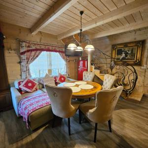a dining room with a table and chairs and a couch at Domek góralski z sauną i jacuzzi 2 in Kościelisko