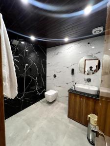 a bathroom with a toilet and a sink and a mirror at Hotel Dream Inn Khajuraho in Khajurāho