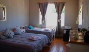 a small room with two beds and a window at Hospedaje Catriel Habitación Privada con Check-in Autónomo in Catriel