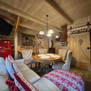 ein Esszimmer mit einem Holztisch und Stühlen in der Unterkunft Domki góralskie z sauną i jacuzzi in Kościelisko