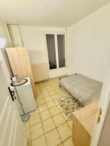 a small room with a bed and a window at Maison Bon Séjour in Livry-Gargan