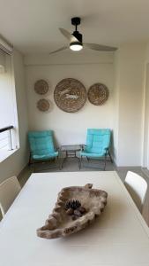 ein Zimmer mit 2 Stühlen und einem Tisch mit einer Schüssel darauf in der Unterkunft Green Park hermoso apartamento vista al lago in Punta del Este